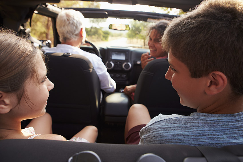 Grandparents Taking Grandchildren On Trip In Open Top Car