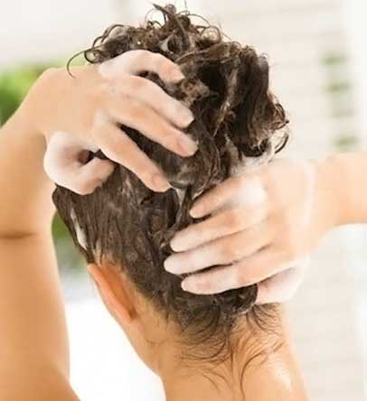 Rear view of a woman shampooing her hair